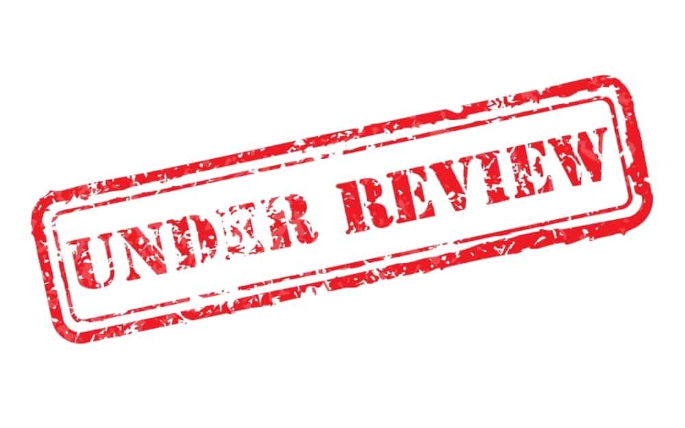 IR35 tax review concept shown by Under review rubber stamp